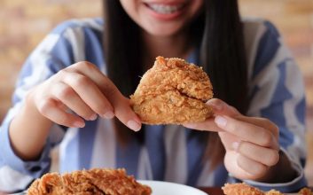 زنی در حال خوردن سینه مرغ سوخاری