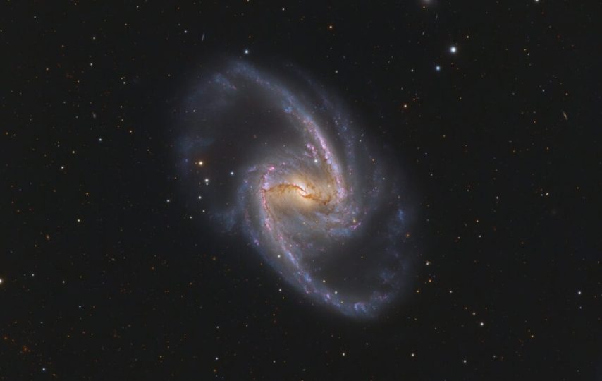 این تصویر رنگی واضح، نواحی برجسته و متمایل به قرمز تشکیل ستاره را در NGC 1365 و در امتداد بازوهای مارپیچی آن نشان می‌دهد.