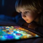 نگاه کودک به صفحه تبلت در تاریکی