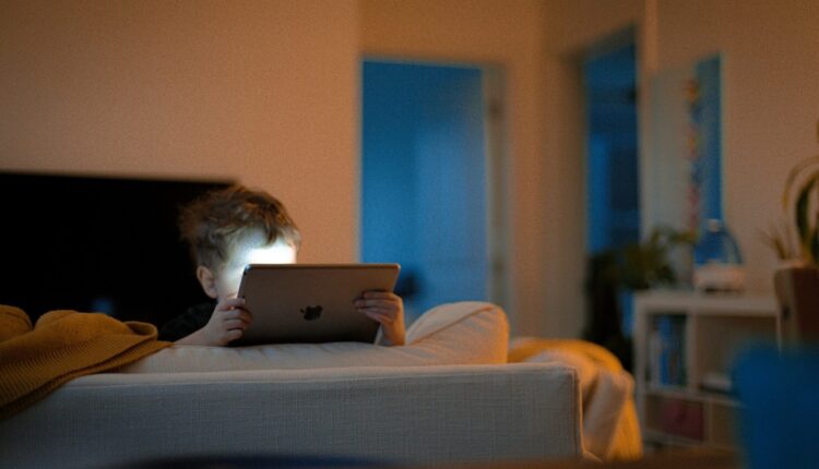 کودک با نور آیپد در تخت خواب