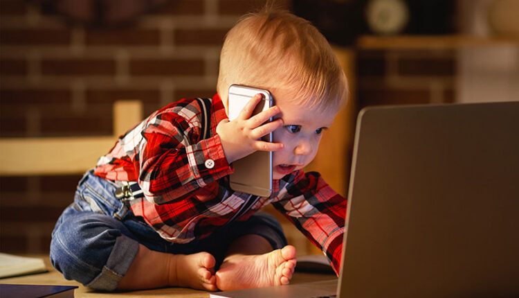 کودک در حال صحبت با موبایل و لپتاپ